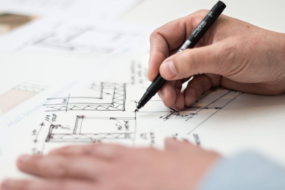 Close-up of hand drawing intricate technical designs on blueprint with pen, ideal for engineering or architecture themes
